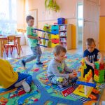 Dzieci bawia się plastikowymi zabawkami na podłodze