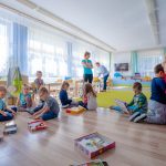 Dzieci siedzą na podłodze i bawią sie puzzlami