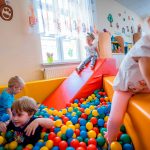 Dzieci bawią się w basenie z kolorowymi piłeczkami