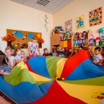 Dzieci bawią się kolorowym dywanem