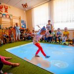 Dziewczynka w czerwonych rajstopach chodzi po podłodze interaktywnej , wokół dzieci