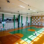 Duża sala gimnastyczna. Świczą na niej dziewczyny w strojach gimnastycznych.