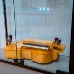 Drewniany instrument muzyczny umieszczony w szklanej gablocie