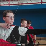 Chłopcy strzelają z łuku na hali