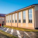 Widok z zewnątrz na salę gimnastyczną z dużymi oknami