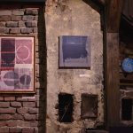 Obrazy w drewnianych ramach zawieszone na ścianach z cegły