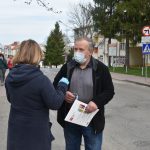 Kobieta w krótkich włosach przekazuje maseczkę mężczyźnie w średnim wieku