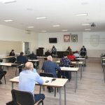 Grupa kilku osób, mężczyzn i kobiet słucha wystąpienia na sali narad w Urzędzie Miejskim w Brzozowie