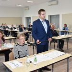 Starsza kobieta zadaje pytanie do mikrofonu.