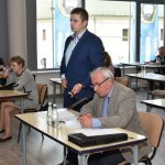 Starszy mężczyzna zadaje pytanie do mikrofonu.