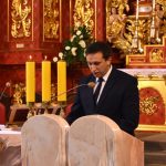 Młody mężczyzna czyta w kościele przy ambonie.