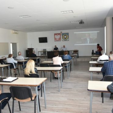 Grupa osób ogląda wideokonferencję.