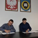 Mężczyźni podpisują dokumenty.