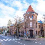 Ogromny budynek z cegły z wieżyczką, znajdujący się przy głównej ulicy.