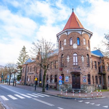 Ogromny budynek z cegły z wieżyczką, znajdujący się przy głównej ulicy.