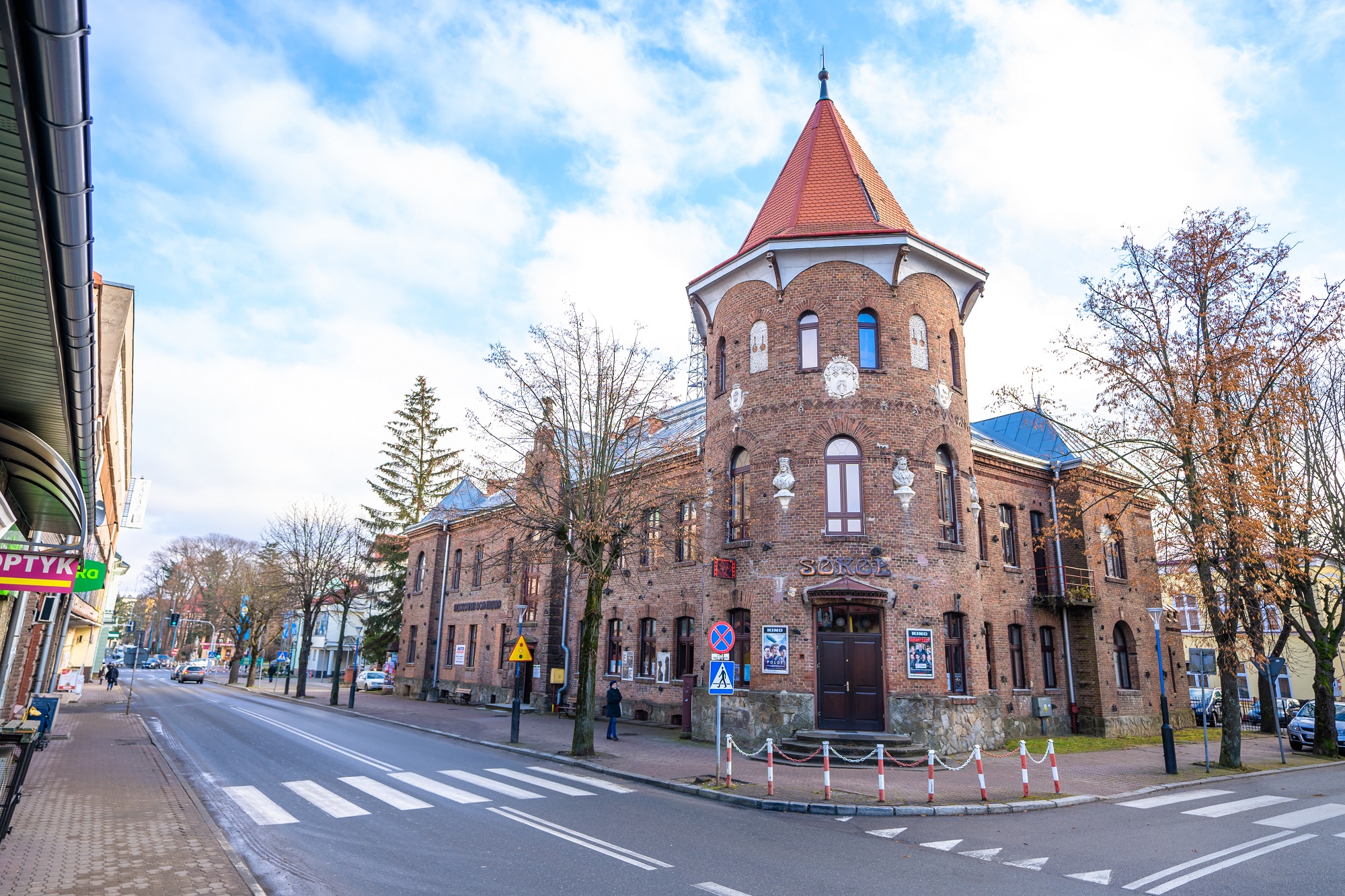 Ogromny budynek z cegły z wieżyczką, znajdujący się przy głównej ulicy.