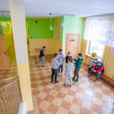 Dzieci w szkole podczas przerwy rozmawiające ze sobą.