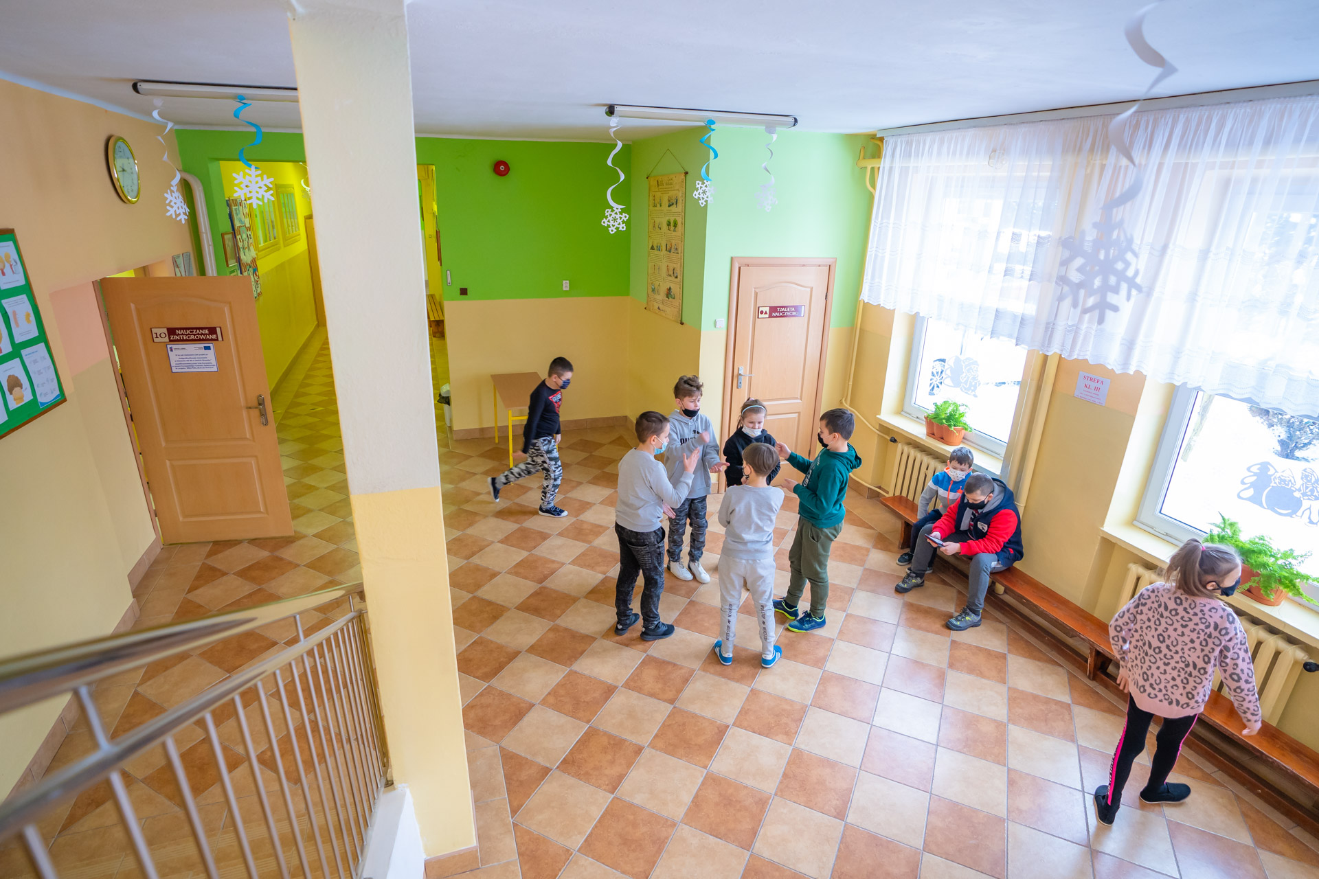 Dzieci w szkole podczas przerwy rozmawiające ze sobą.