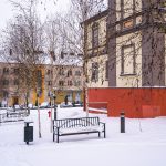 Zaśnierzony plac z budynkami z kolorowymi elewacjami