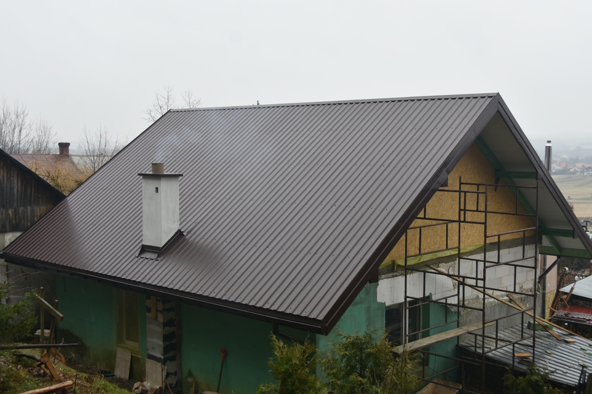 Budynek murowany z nowym dachem z brązowej blachy.