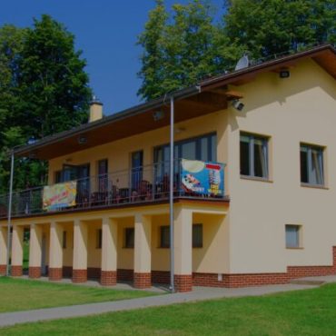 Budynek z jasną elewacją na terenie zielonym.