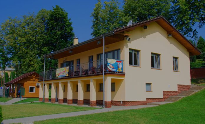 Budynek z jasną elewacją na terenie zielonym.