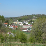 Teren zabudowany otoczony lasami i łąkami.