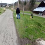 Dwóch mężczyzn w stroju strażaka rozdaje ludziom maseczki pod domem.