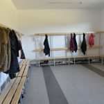 Szatnia w szkole. Jasne ławeczki i wieszaki.