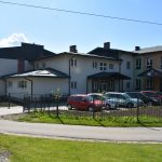 Jasny budynek szkoły z zewnątrz.