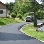 Droga wyłożona asfaltem, jeździ po niej walec.