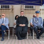 Grupa osób m.in. policjantów i cywili siedząca na krzesłach.