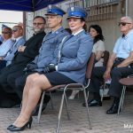 Grupa osób m.in. policjantów i cywili siedząca na krzesłach.