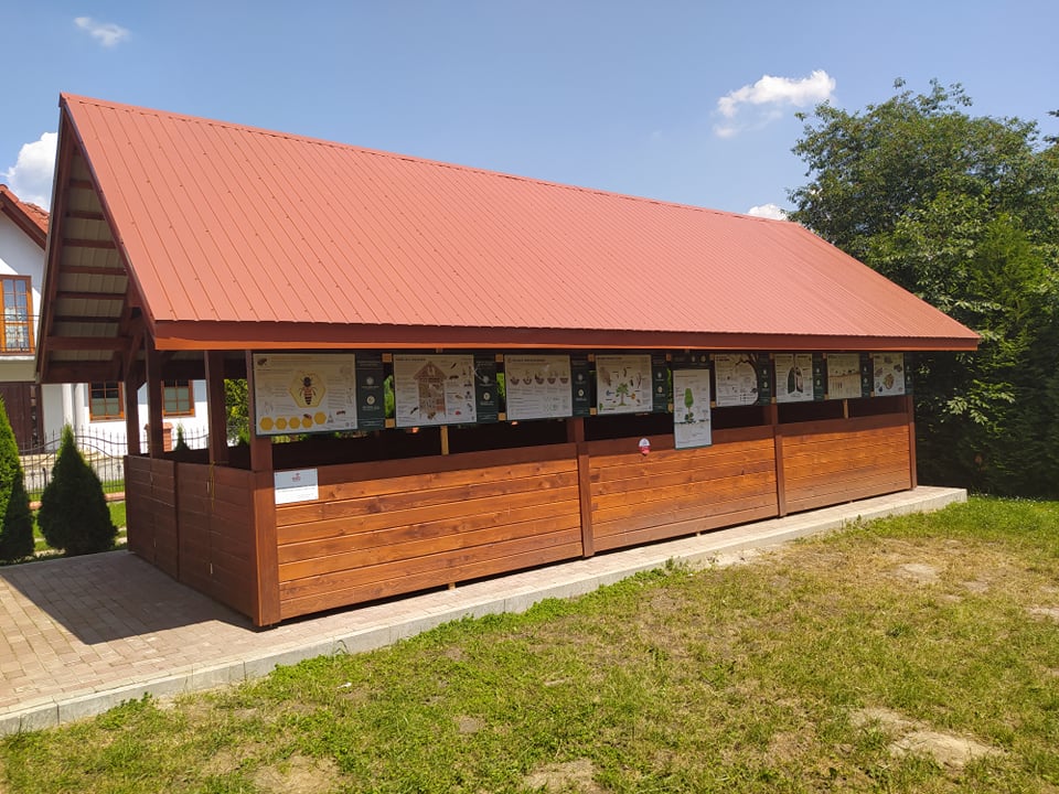 Drwaniana altana W tle trawa i błękitne niebo.