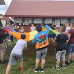 Grupa młodzieży w czasie zabaw. W tle drwaniana altana.