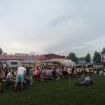 Grupa osób zgromadzana na stadionie na imprezie.