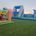 Dmuchana zjeżdzalnia i atrakcje dla dzieci na stadionie.