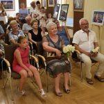 Grupa osób zebrana na wydarzeniu artystycznym.