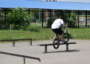 Młody mężczyzna wykonujący popisy na BMXie.