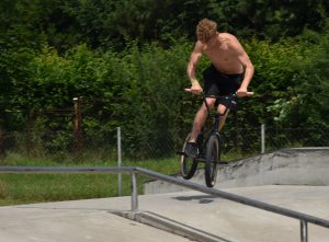 Młody mężczyzna wykonujący popisy na BMXie.