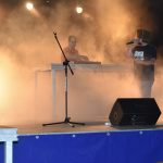 Dwóch mężczyzn na scenie podczas wykonywania utworu muzycznego.