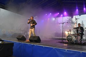 Zespół złozony z trzech mężczyzn, dający występ na scenie.