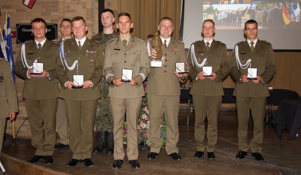 Grupa osob w mundurach wojskowych, pozujących z wręczonymi wyróżnieniami.