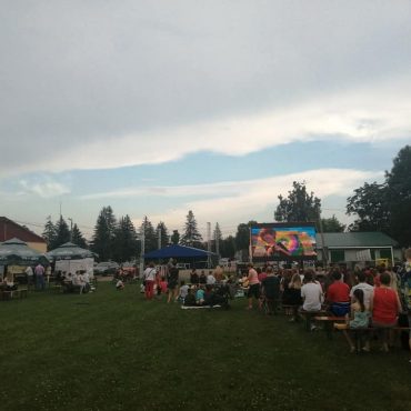 Znaczna grupa osób uczestnicząca w zabawie na stadionie.
