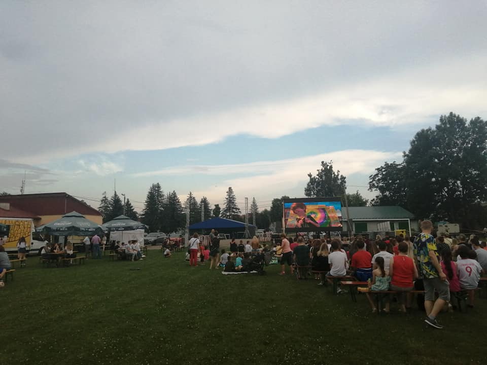 Znaczna grupa osób uczestnicząca w zabawie na stadionie.
