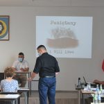 Meżczyzna podający mikrofon kobiecie na spotkaniu.