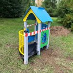 Urządzenie na placu zabaw przy przedszkolu w kształcie domku.