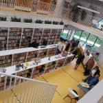 Grupa osób zwiedza bibliotekę.