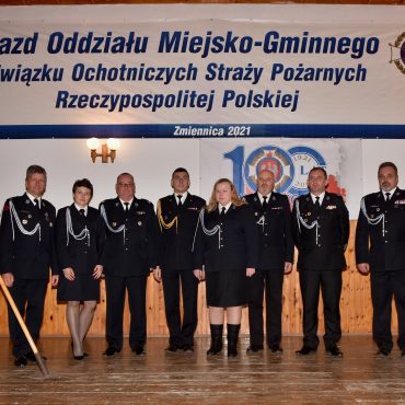 Druhny i druhowie OSP pozujący do zdjęcia ubrani w mundury galowe.