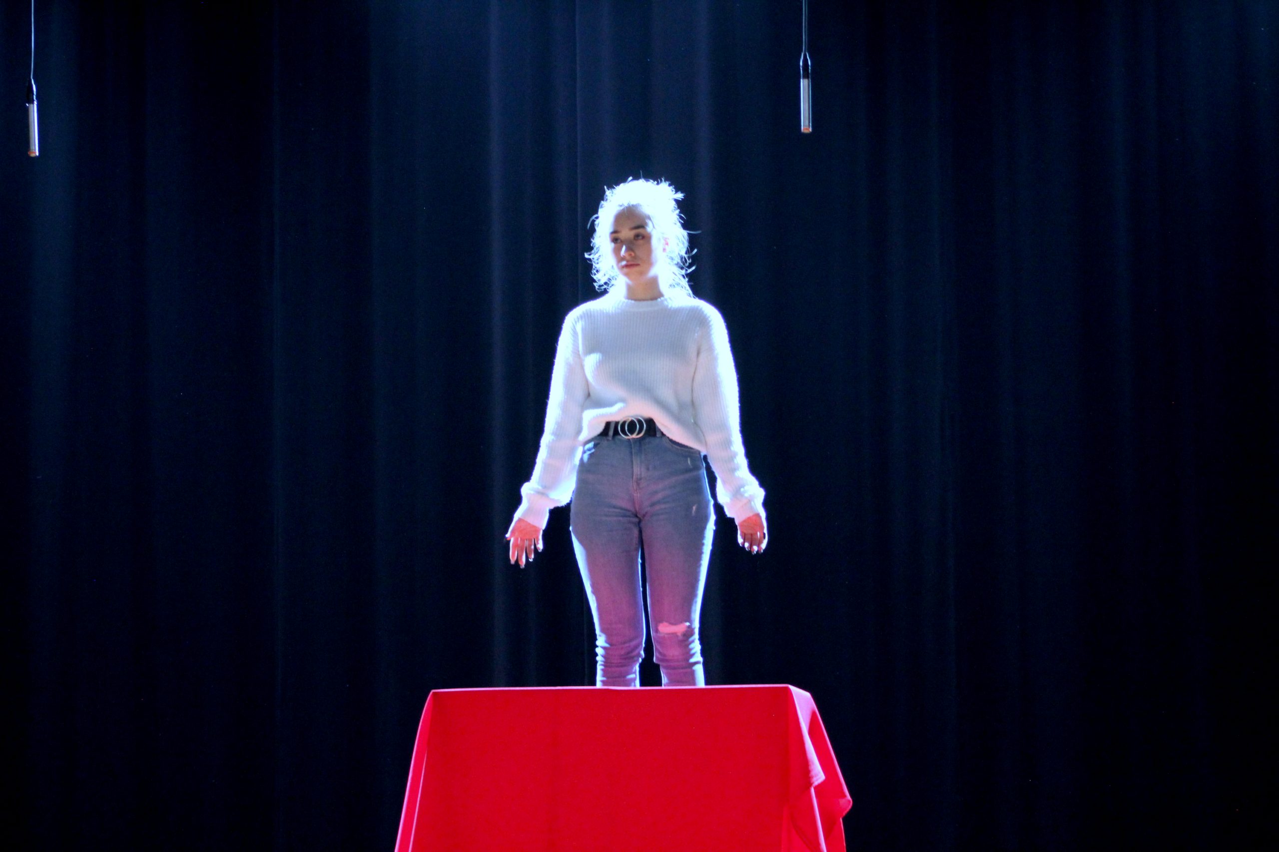 Młoda dziewczyna stojąca na stole z czerwonym obrusem